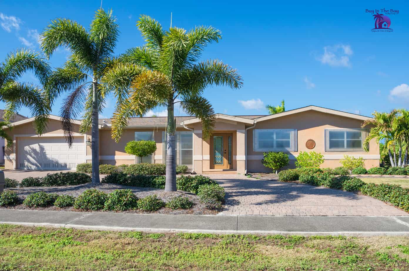 ranch style home that is tan with palm trees, similar to what would be found in Brandon FL