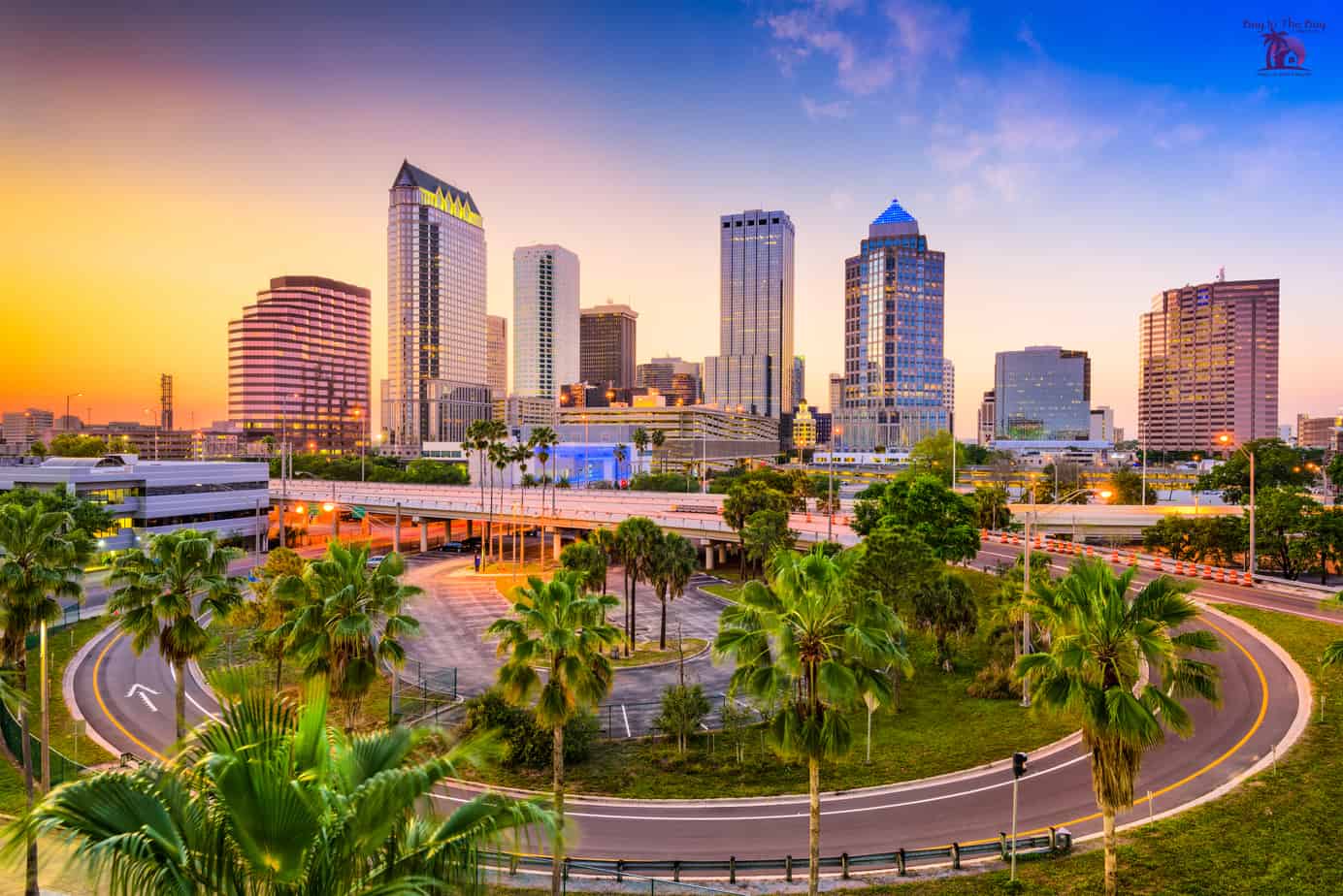 colorful skyline with sunset and tall building showing tampa homes for sale