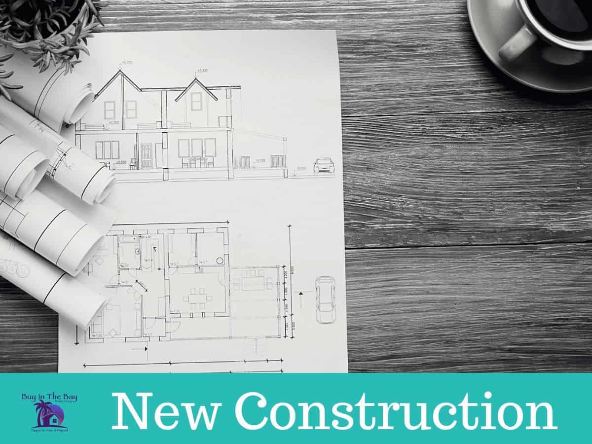black and white blueprints and coffee on a table showing new construction tampa bay