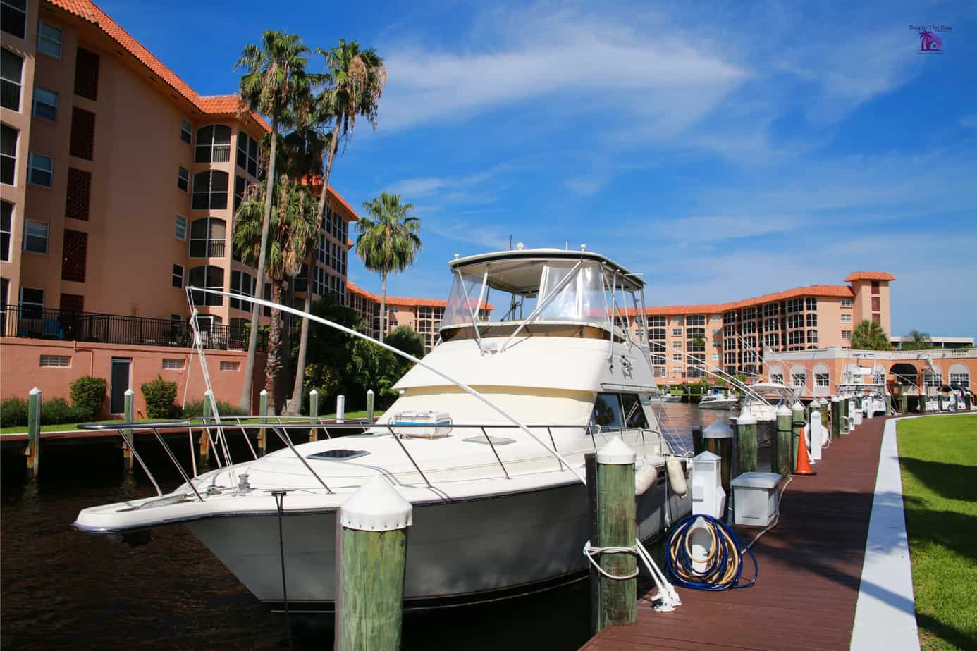 Image of pink condo building on the water with a white yacht tied to a boat slip in a condo community in a similar home for sale in pasadena fl with the zip code of 33707