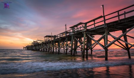 Sunset at Redington Pier at Redington Beach FL in the ip code of 33708 with a multicolored sky, ocean, and long wooden pier