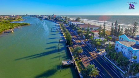 Ariel View of Indian Shores Florida in the zip code of 33785 with a long inlet with multi colored homes with the gulf of mexico on one side and the Narrows inlet on the other side 