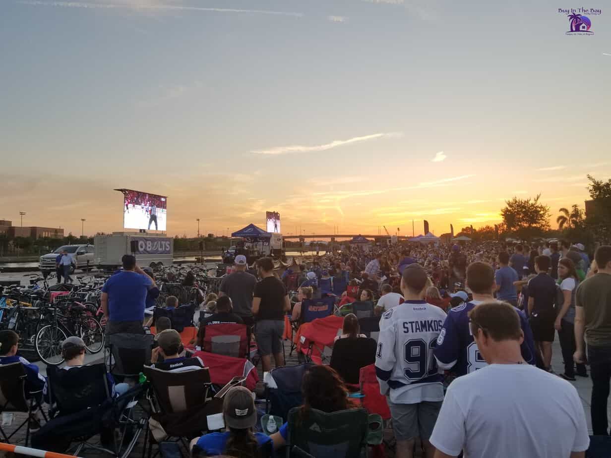 Image of a group of people on the lawn at Armature Works watching the Tampa Bay Lightning Play Hockey. This image is for Tampa Heights Houses For Sale.