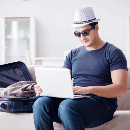 guy with hat looking for a home on his laptop