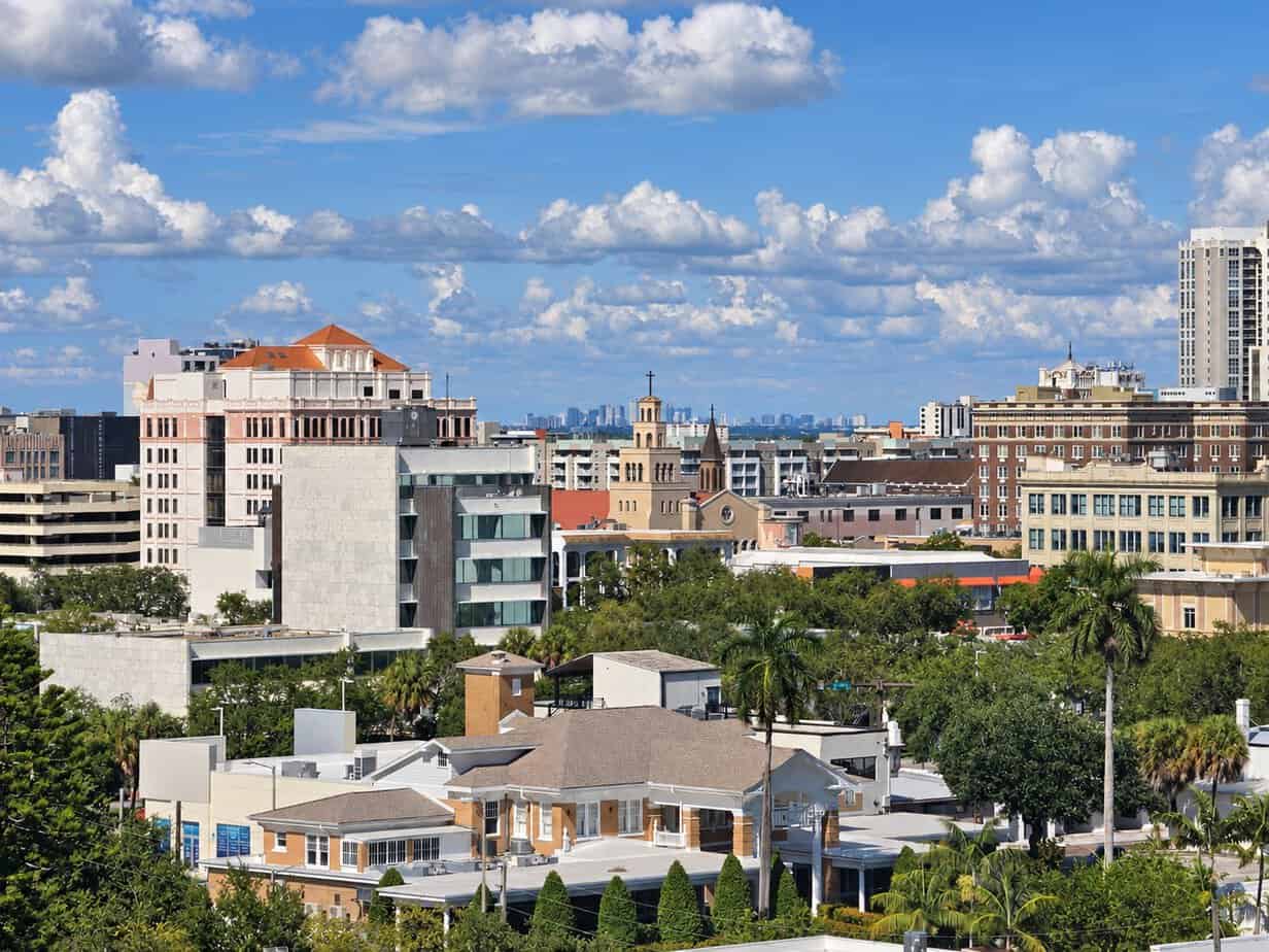 Downtown St. Petersburg buildings with a church tower, palm trees, and neighborhood rooftops