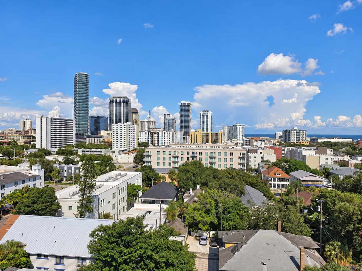 Downtown St. Petersburg skyline with high-rise buildings, neighborhood rooftops, and Tampa Bay in the distance
